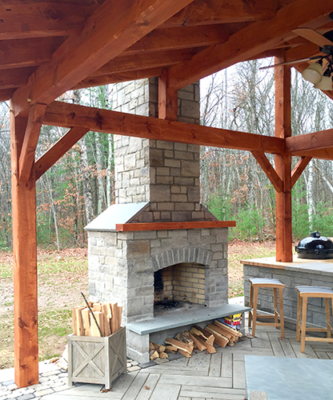 Outdoor fireplace with a tall chimney in a gazebo with a kitchen
